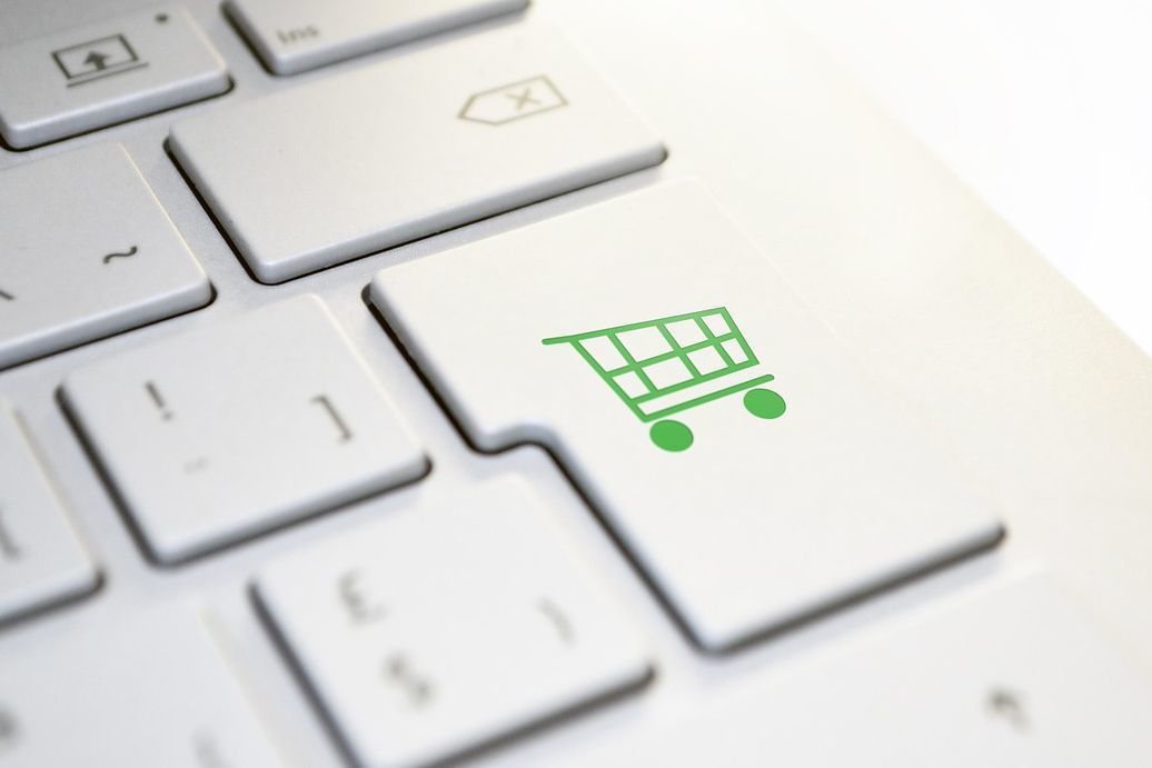 パソコンのキーボードのEnterキー部分が、ショッピングカートのアイコンにデザインされた写真。お支払いやチェックアウトを象徴する視覚的な演出で、オンラインショッピングにおけるスムーズな決済プロセスの利便性と、デジタル決済・eコマースの利便性を表現したビジネスコンセプトのイメージ。