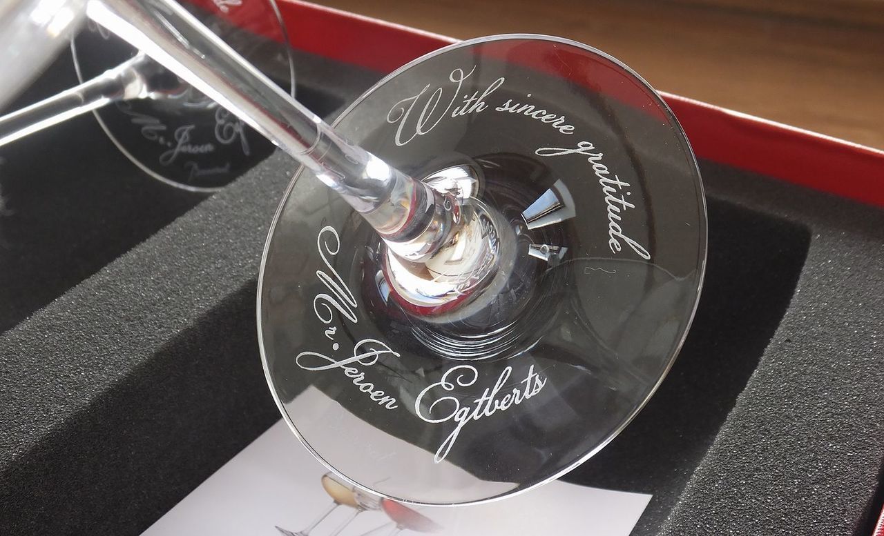 シャトーバカラ ワイングラスの底面に、流麗な書体で『With sincere gratitude』のメッセージとお名前を名入れ彫刻した写真。グラスを傾けるたびに感謝の言葉が目に触れる、洗練された輝きと特別感を演出するパーソナライズギフトのイメージ