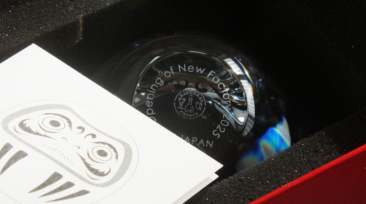 バカラのクリスタル製置き時計『ラランドクロック』に、クリニックの開院祝いとしての名入れ彫刻を施したサンプル画像。厚みのある円形クリスタルの前面下部に、『祝 御開院』の文字が、誠実さと信頼感を感じさせる格調高い和文書体で精巧に刻印されている。バカラならではの透明度と光の屈折が、医療機関の清潔感と輝かしいスタートを象徴しており、受付やカウンタースペースに置くことで、末永く時を刻み続ける祝福の記念品としての存在感を放っている様子を視覚的に表現している。