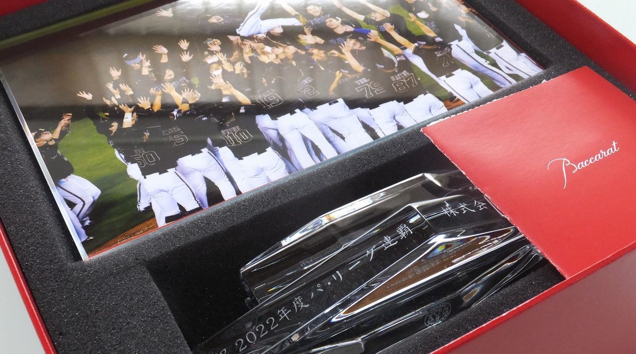 バカラのクリスタル製フォトフレーム『アビス』の重厚な台座部分に、プロ野球パ・リーグ連覇を祝した名入れ彫刻を施したサンプル画像。直線的でエッジの効いた台座に、『祝 2022年度パ・リーグ連覇』の文字と『贈り主名』が、勝利の力強さを感じさせる端正な書体で精緻に刻印されている。深海（アビス）をイメージした深いカットが光を多方向に反射し、連覇という歴史的な偉業の輝きを象徴しており、歓喜の瞬間を収めるための、威厳と誇りに満ちた最高級のアニバーサリーギフトであることを視覚的に表現している。