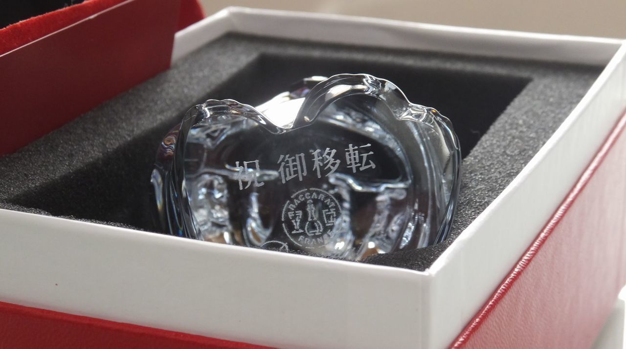 バカラのクリスタル製『招き猫』の底面に、移転祝いの名入れ彫刻を施したサンプル画像。新しい場所でのさらなる繁栄を願う招き猫の底面に、『祝 御移転 [店舗名]』の文字が、縁起の良い清廉な書体で精巧に刻印されている。バカラ特有の透明感溢れるクリスタルが、新天地での輝かしいスタートを象徴し、表からは見えない底面への彫刻が、店舗の歴史に寄り添う粋な記念品であることを視覚的に表現している。