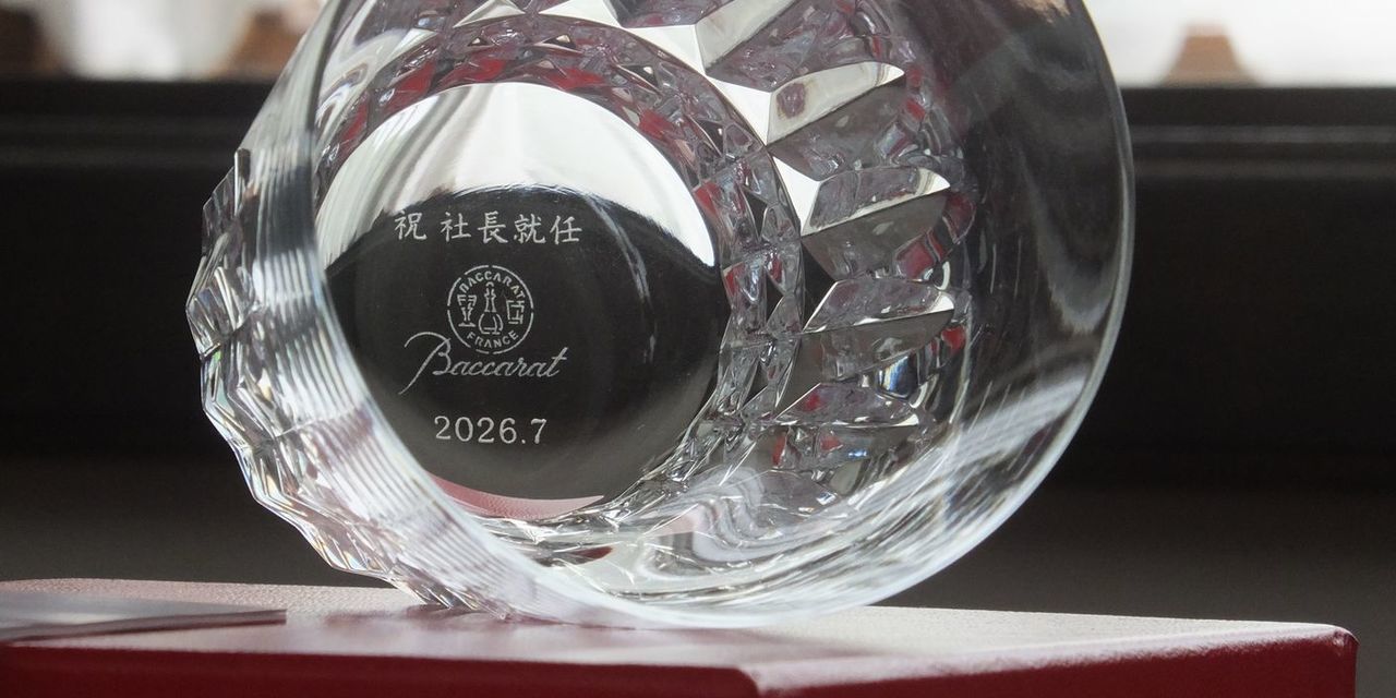 バカラ（Baccarat）の『ピカデリー』タンブラーのグラス底面に、『祝 社長就任 2026.7』の文字が精緻に名入れ彫刻された写真。洗練されたカットが施された最高級クリスタルガラス越しに、底面の記念刻印が美しく浮かび上がり、重厚感と気品を兼ね備えた逸品。新社長への就任祝いやエグゼクティブへの昇進記念など、人生の大きな節目を祝福する最高峰のパーソナライズドギフトにふさわしいイメージ。