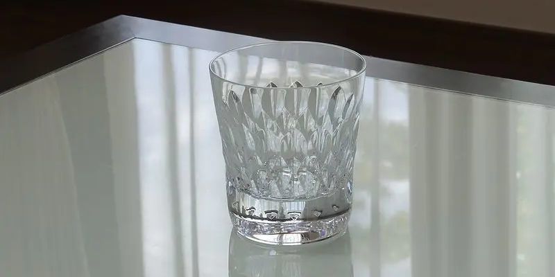 バカラのアルマニャックタンブラーが、テーブルの上に置かれている写真。宝石のような美しい輝きを作り出すしずくのようなカットのつながりが特徴的です。特別な功績を称える表彰品や、感謝の気持ちを伝える特別な贈り物として、格式高い法人ギフトにふさわしい逸品です。