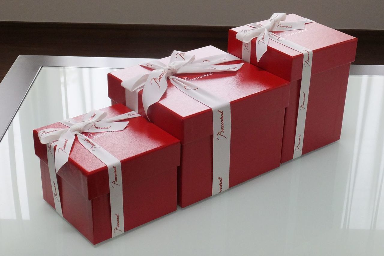 バカラのレッドボックスが大中小3サイズ、テーブルに並べられた写真。グラスやオブジェなど、様々なギフトに対応できるサイズバリエーションを仙台から提供するイメージです。