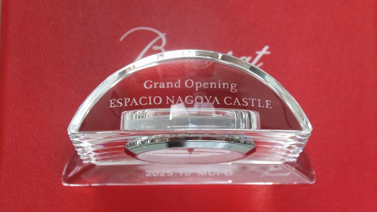 バカラの『ラランド』クリスタルクロックの上部に、格調高いエッチングで『Grand Opening ESPACIO NAGOYA CASTLE』と名入れ彫刻を施したサンプル写真。円形の美しいカッティングが光を反射し、最高級ホテルの開業という輝かしい門出と、刻まれていく新たな歴史を優雅に祝福する、洗練された法人向け開院・開業記念ギフトのイメージ。