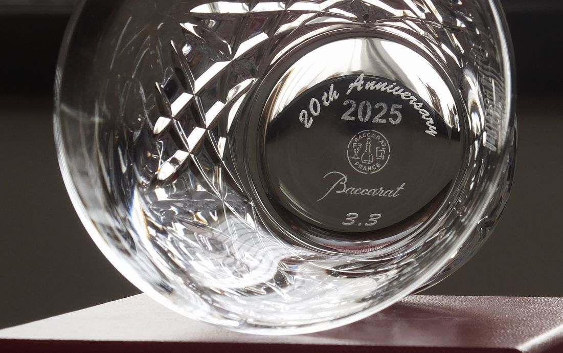 バカラのアリアタンブラー2025の底面に、『20th anniversary』と日付を名入れ彫刻した写真。透明なクリスタルの底面に、20周年を祝うメッセージと日付が繊細に刻まれ、大切な節目を祝う特別な記念品としての価値と、洗練された美しさを際立たせています。