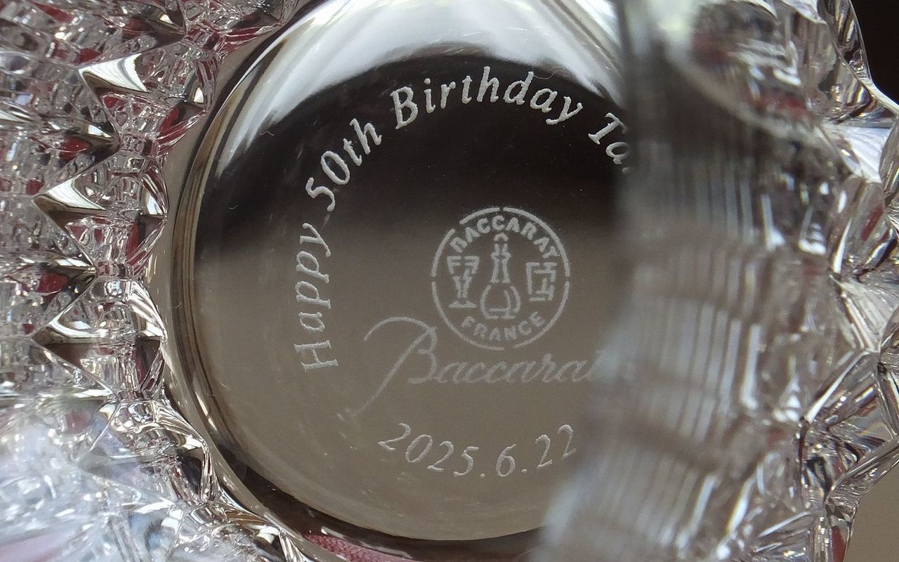 バカラ（Baccarat）のクリスタルグラス『ヴィータ ハイボール』の底面に、英語で『Happy 50th Birthday』のメッセージ、お名前、および『2025.6.22』の日付が精緻に名入れ彫刻された写真。複雑でモダンなカットが織りなす最高級クリスタルならではの輝きに、50歳という人生の大きな節目を祝福する刻印が映え、50歳の誕生日祝いや特別な記念日に贈る最高峰のパーソナルギフトにふさわしい格調高いイメージ。